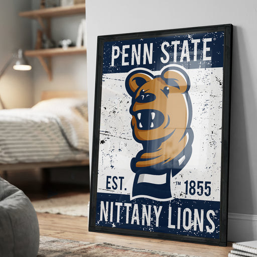 A framed poster of the Penn State Nittany Lions, featuring a cartoon bear mascot and the text "Penn State EST. 1855 NITTANY LIONS".
