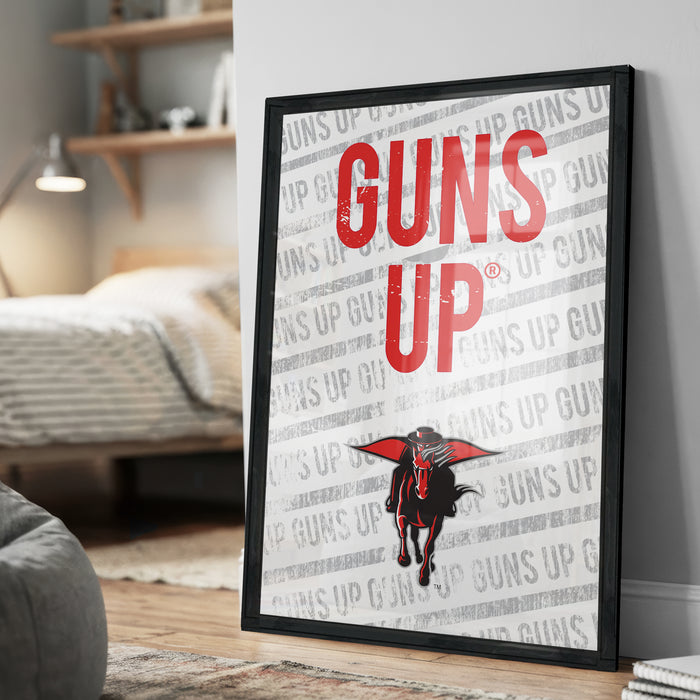 A framed poster with the text "GUNS UP" prominently displayed, featuring a graphic of a gun and a person's face.