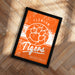 a framed poster with the text "CLEMSON TIGERS BASKETBALL" on it, placed on a wooden floor.