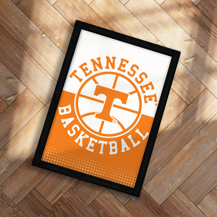A framed poster with the text "TENNESSEE BASKETBALL" on it, placed on a wooden floor.