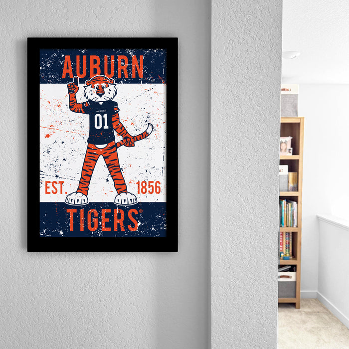 a framed poster of a tiger mascot with the text "AUBURN TIGERS" and "EST. 1856" on it, hanging on a wall.