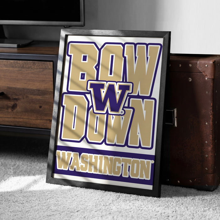 A framed poster with the text "BOW W down WASHINGTON" is displayed on a carpeted floor next to a wooden chest.