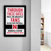 a framed sign with the text "THROUGH THESE GATES PASS THE GREATEST FANS IN COLLEGE FOOTBALL. MEMORIAL STADIUM UNIVERSITY OF NEBRASKA LINCOLN" on a wall.