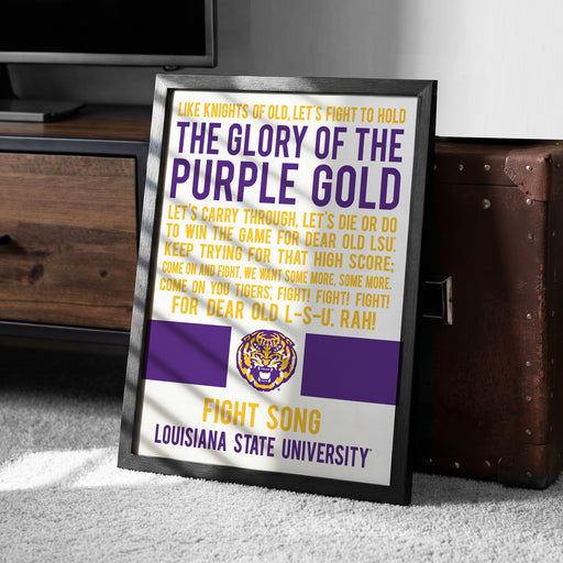 a framed poster with text and a tiger logo, placed on a carpeted floor next to a wooden chest.