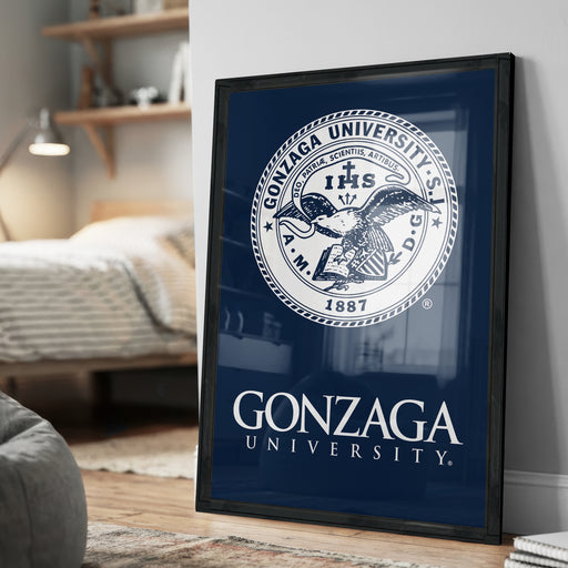 A framed poster of Gonzaga University's seal is displayed on a wall in a room.