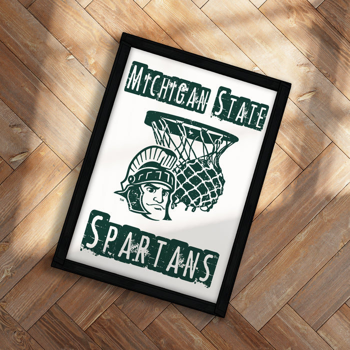 A framed poster with the text "Michigan State" and "Spartans" on it, featuring a graphic of a basketball player.
