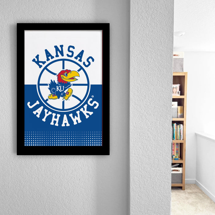 A framed poster of the Kansas University Jayhawks basketball team is hanging on a wall.
