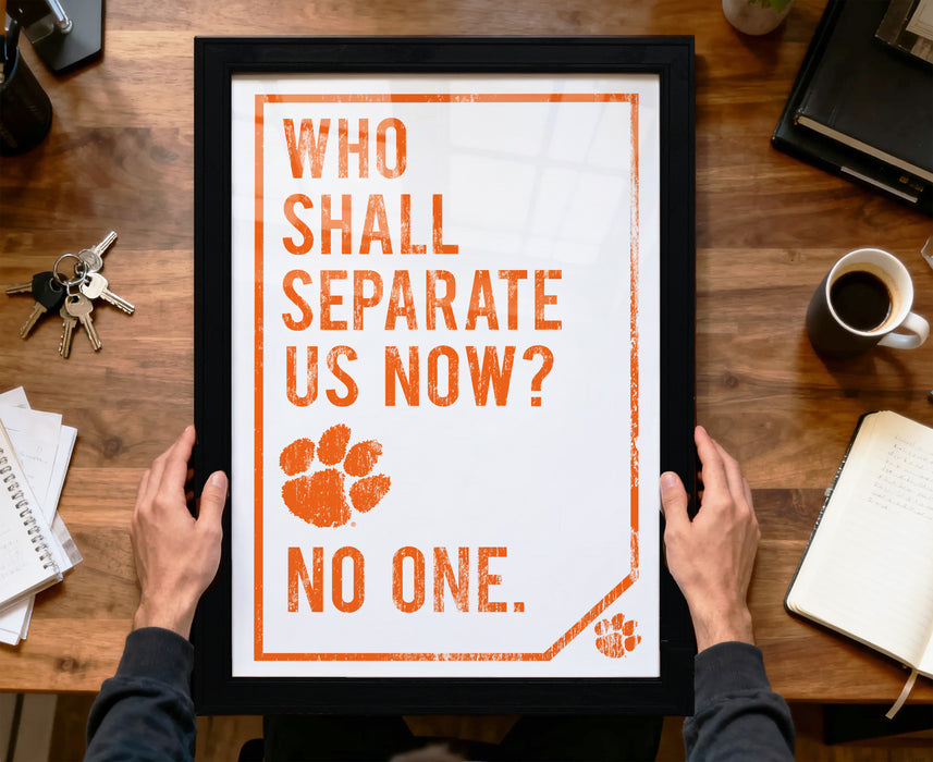A person is holding up a framed poster with the text "WHO SHALL SEPARATE US NOW? NO ONE." The poster features a paw print and a key, suggesting a message related to separation or exclusivity.