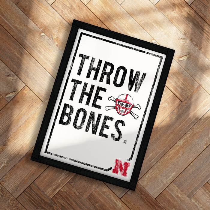 A framed poster with the text "THROW THE BONES" and a football helmet with a skull and crossbones design.