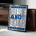 A framed poster with the text "RISE AND Roar" and a cat logo, placed on a carpeted floor next to a wooden chest.