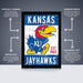 The image is a poster featuring the Kansas Jayhawks, a college sports team. The poster is a framed poster with a bird illustration and text, and it is described as an officially licensed poster, a premium printed poster, and a perfect gift. The poster is shipped flat and comes in boxes that are easy to gift wrap.