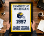 A framed poster titled "UNIVERSITY OF MICHIGAN 1997 COLLEGE FOOTBALL NATIONAL CHAMPIONS" is being held by a person's hands.