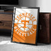 A framed poster of the Tennessee basketball team logo is displayed on a carpeted floor next to a wooden chest.