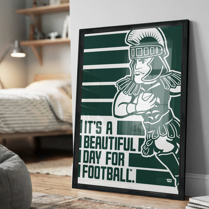 A framed poster featuring a cartoon character in a football uniform, with the text "It's a beautiful day for football" displayed on the poster.