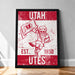 A framed poster featuring the logo and text of the University of Utah, with a red and white color scheme.