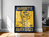 A framed poster of a yellow and blue bird mascot, likely representing Marquette University, standing on a wooden floor.
