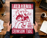 A framed poster of an elephant holding a football, with the text "ALABAMA CRIMSON TIDE EST. 1892" printed on it.