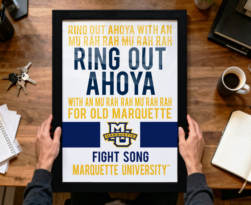 A framed poster with text and a Marquette University logo, held by a person's hands.