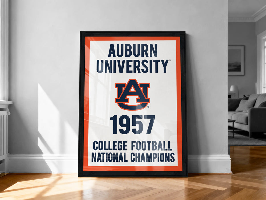 A framed poster on a wall, displaying the text "Auburn University" and "College Football National Champions" along with the Auburn logo and the year "1957".
