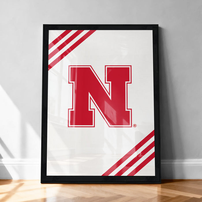 A framed poster with a large red letter "N" on a white background, surrounded by red diagonal stripes.