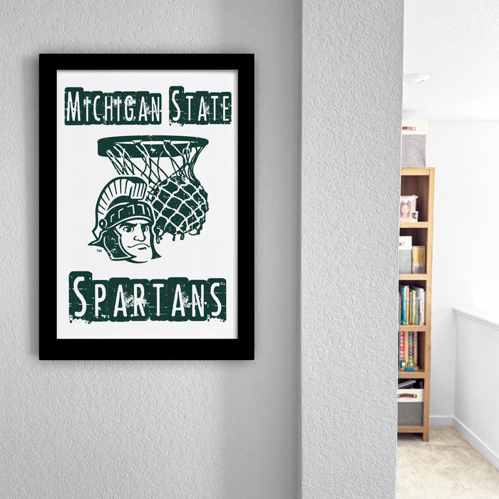 A framed poster of the Michigan State Spartans basketball team hangs on a wall, featuring the team's logo and name.