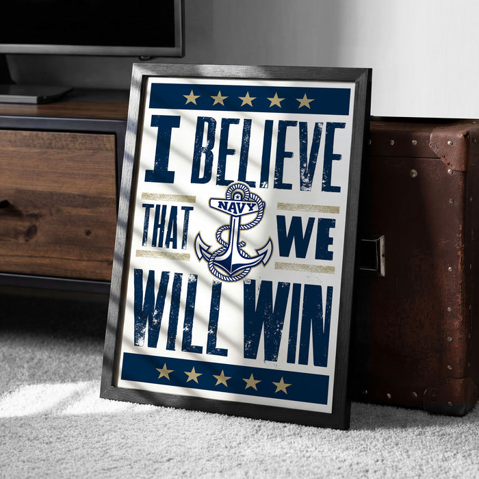 A framed poster with the text "I BELIEVE THAT WE WILL WIN" and an anchor symbol, placed on a carpeted floor next to a wooden chest.