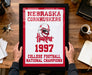 A framed picture of the Nebraska Cornhuskers, a football team, celebrating their 1997 College Football National Champions.