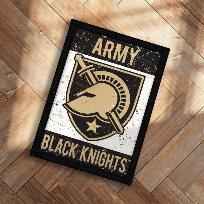 A framed poster with the text "ARMY BLACK KNIGHTS" and a graphic of a helmet and sword, placed on a wooden floor.