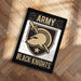 A framed poster with the text "ARMY BLACK KNIGHTS" and a graphic of a helmet and sword, placed on a wooden floor.
