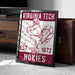A framed poster featuring a turkey and the text "VIRGINIA TECH EST. 1872 HOKIES" is displayed on a carpeted floor next to a wooden chest.