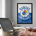 a framed poster of the Kansas Jayhawks basketball team on the wall, with a person's hands typing on a laptop in the foreground.