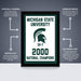 The image is a framed poster from Michigan State University, celebrating the 2000 National Champions. The poster features the Michigan State University logo and the text "2000 NATIONAL CHAMPIONS". The poster is officially licensed and is a premium printed poster, offering a perfect gift for any space. The poster is shipped flat and comes in boxes that are easy to gift wrap.