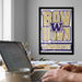 a person working on a laptop at a desk, with a framed poster of the Washington University team on the wall behind them.