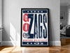 A framed poster with the text "GO ZAGS" and the logo of Gonzaga University, displayed on a wall in a room.