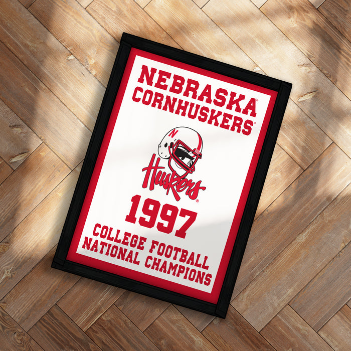 A framed poster celebrating the 1997 Nebraska Cornhuskers college football national championship, featuring the team's logo and text.