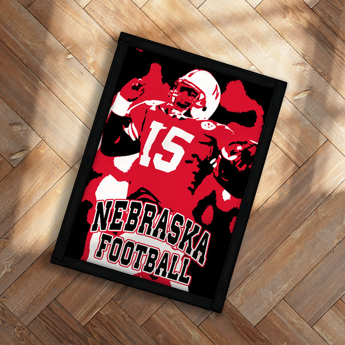 A framed poster of a football player in a red uniform with the number 15, representing the state of Nebraska.