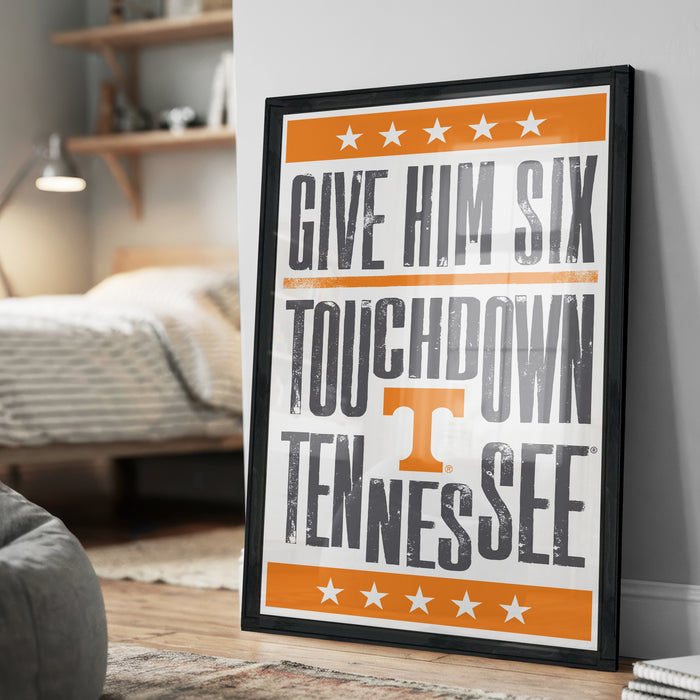A framed poster with the text "GIVE HIM SIX TOUCHDOWN TENNESSEE" on it, along with an orange border and white stars.