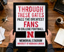 A framed sign with text stating "THROUGH THESE GATES PASS THE GREATEST FANS IN COLLEGE FOOTBALL. N" is being held by a person's hands.