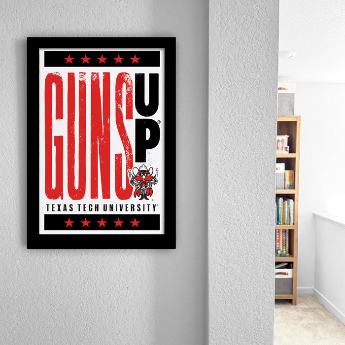 a framed poster with the text "GUNS UP" and "TEXAS TECH UNIVERSITY" printed on it, hanging on a wall.
