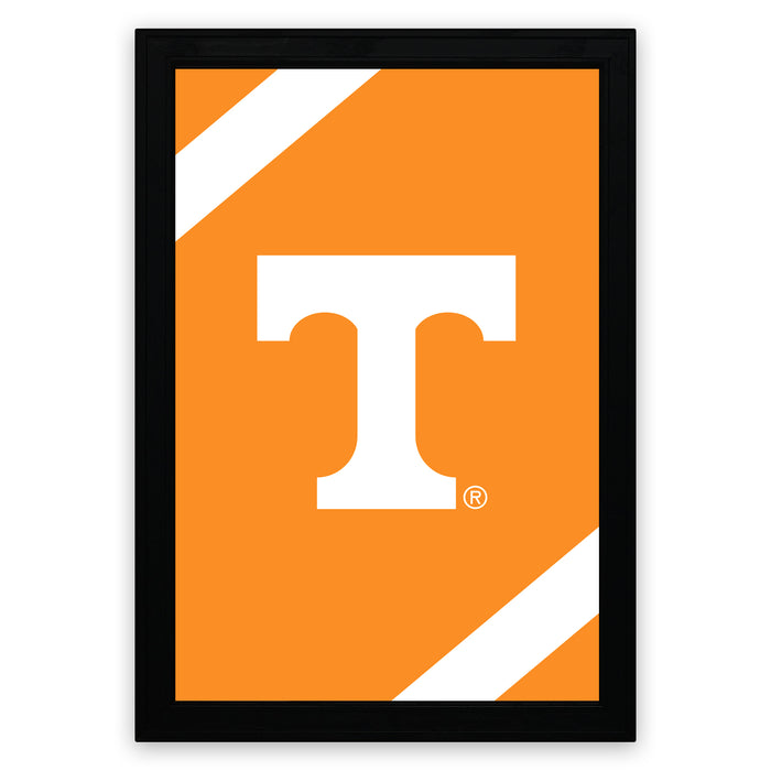 a framed poster with a large white letter "T" on an orange background.