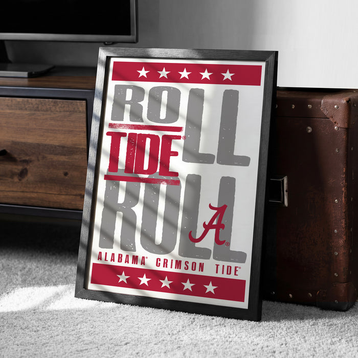 A framed poster with the text "ROLL TIDE RULL" and "ALABAMA'S GRIMSON TIDE" printed on it, placed on a carpeted floor next to a wooden chest.