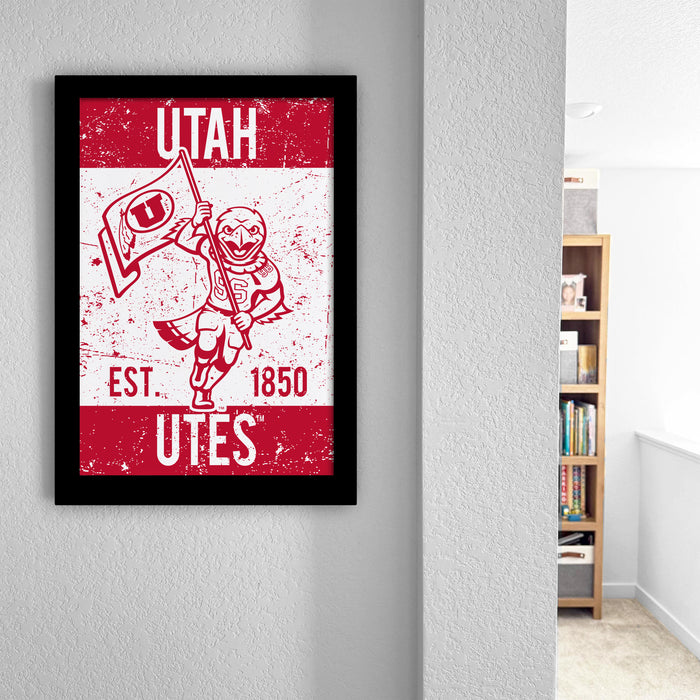 a framed poster of a character holding a flag, with text that reads "UTAH EST. 1850 UTES".