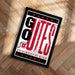 A framed poster with the text "GO OUTS" and "UNIVERSITY OF UTAH" printed on it, placed on a wooden floor.