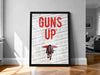 A framed poster with the text "GUNS UP" prominently displayed, along with a graphic of a person in a red cape.