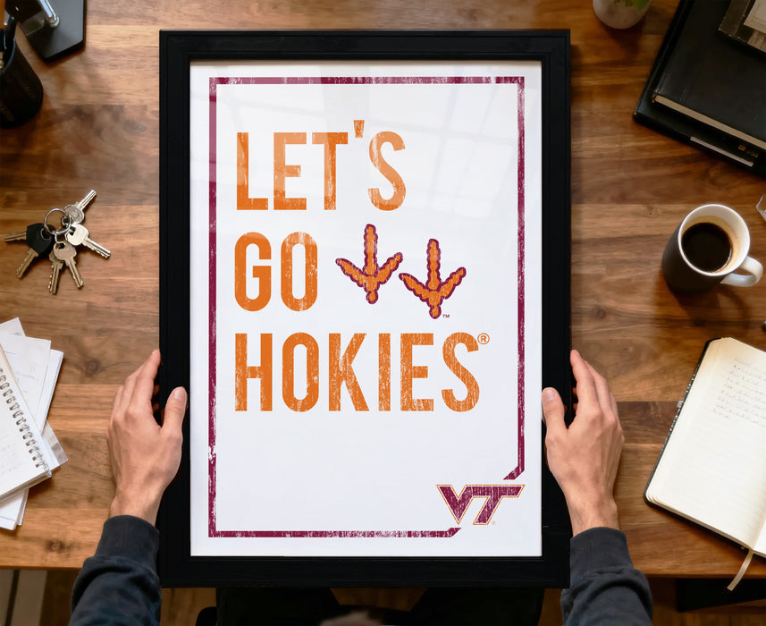 A person is holding up a framed poster with the text "LET'S GO HOKIES" and a graphic of a bird.