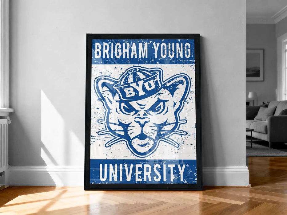 A framed poster of the University of Utah's mascot, a cat wearing a hat, is displayed on a wall in a room.
