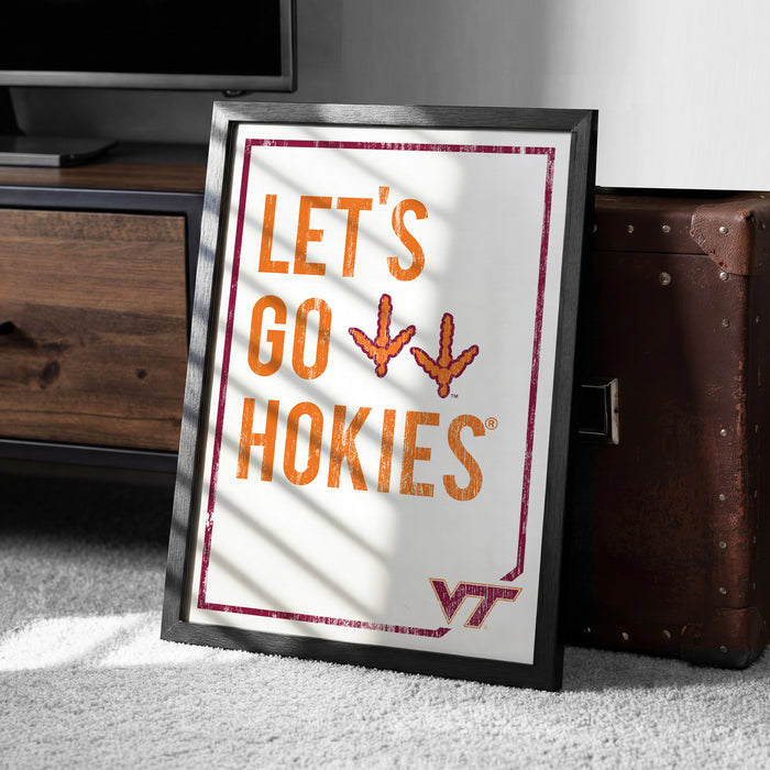 A framed poster with the text "LET'S GO HOKIES" is displayed on a carpeted floor next to a wooden chest.