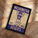 A framed poster featuring a cartoon image of a mascot with the text "WASHINGTON EST. 1861 HUSKIES" on it.