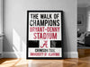 a framed poster with text that reads "The walk of champions BRYANT-DENNY STADIUM A CRIMSON TIDE UNIVERSITY OF ALABAMA"