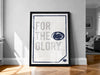 A framed poster with the text "FOR THE GLORY" and a logo, placed on a wooden floor against a white wall.